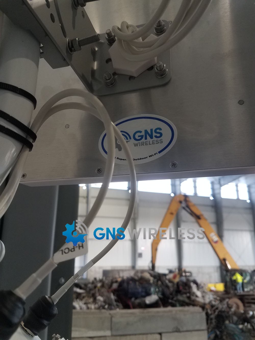 Outdoor wireless equipment mounted on a pole overlooking a commercial work area